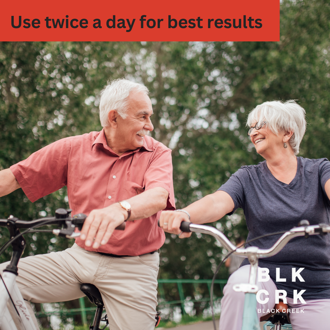 Two people riding on bikes, smiling at each other on a sunny day. Caption: Use twice a day for best results. The Black Creek CBD logo is at the bottom.