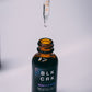 The Black Creek CBD Calm Tincture, 600 mg on a white background. The CBD tincture dropper is raised, with a drop of CBD oil about to drop back into the bottle