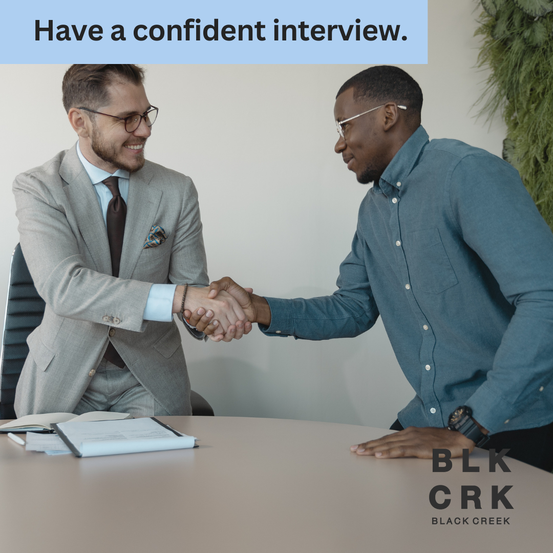 Two well-dressed men shake hands in an office setting. The text "Have a confident interview" is at the top. The logo for Black Creek CBD is at the bottom